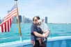 A woman holding her dog on the cruise with Chicago in the background on the Canine Cruise in Chicago Illinois.