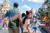 A family waking through Walt Disney World with bubbles being blown behind them in Orlando, Florida, USA.