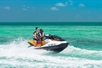 Two riders jetskiing over the waves on the Fury Water Adventure Ultimate Jet Ski Tour of Key West in Key West, Florida.