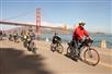 Group biking with the Golden Gate Bridge in the background.