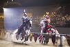 Two knights battle on horseback in the middle of the arena