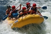 Wearing red safety helmets, guests take a big splash in their yellow raft