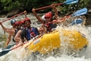 Professional river guide maneuvers raft and group through the white water rapids on the Ocoee River.