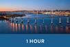 Wide shot of a large bridge going over water with the sun setting in the background along with the city and a blue banner saying "1 Hour" with San Diego Dining Cruise by Hornblower in San Diego, California, USA