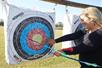 Woman grabs arrow out of archery target