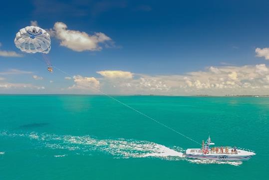 A view of the boat and parasail with passengers in it on the ocean on the Fury Water Adventure Parasailing in Key West, Florida.
