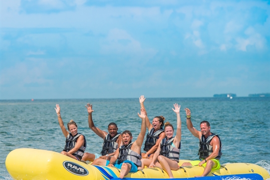 Tour group waving while riding the "banana" boat on the Fury Water Adventure Ultimate Adventure H2.0 in Key West, Florida.