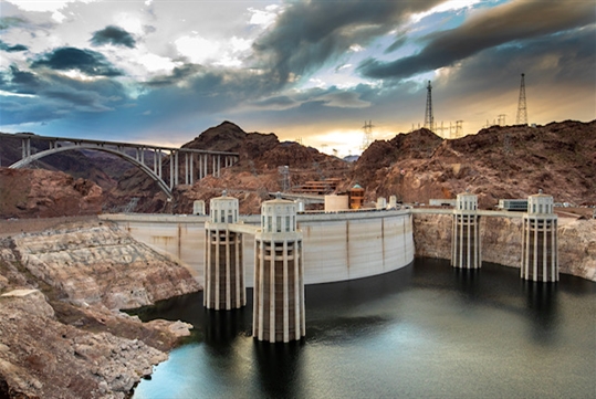Hoover Dam with bridge and mountains in the background