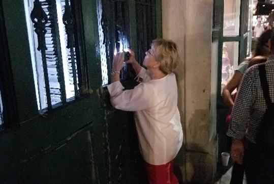 A woman takes a photo during the Family-Friendly Ghost Tour