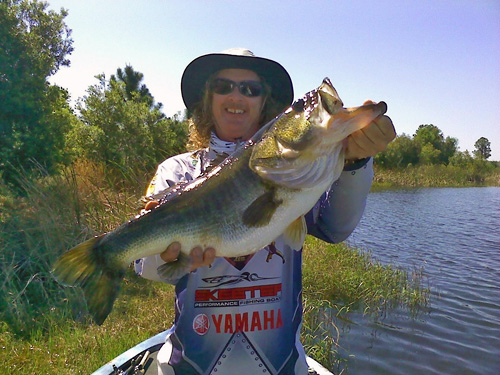 Man holds large bass up for photo